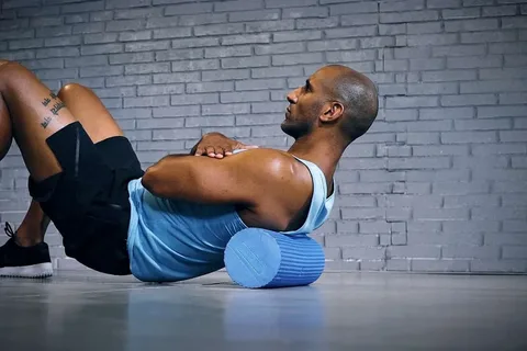 رياضي يخضع لجلسة Cryotherapy في غرفة التبريد أو يستخدم Foam Roller على عضلاته.

