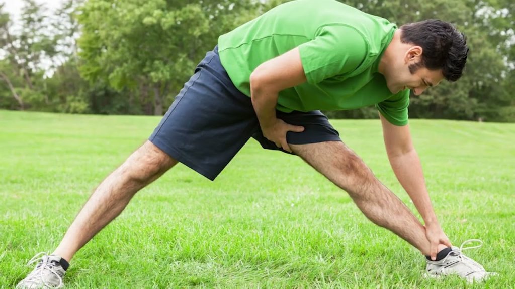 رياضي يمارس المشي الخفيف أو تمارين الإطالة بعد التمرين لتعزيز التعافي النشط.